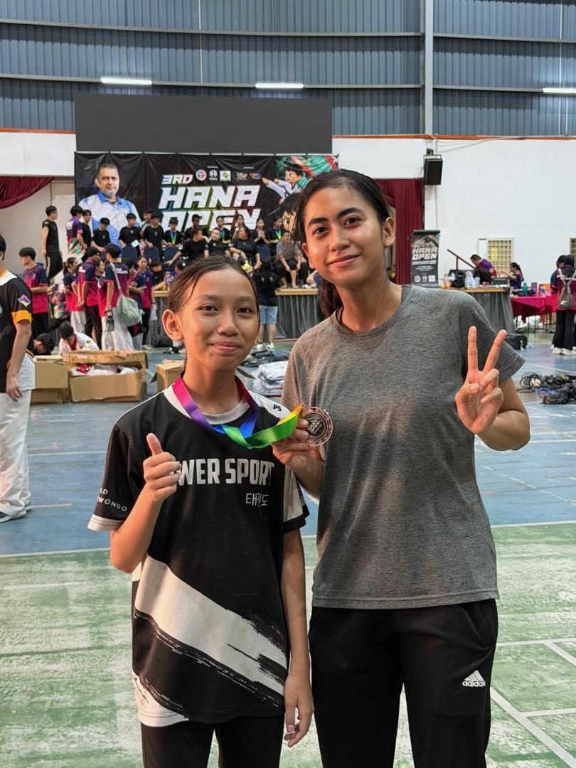 Power Sport student and coach with a medal
