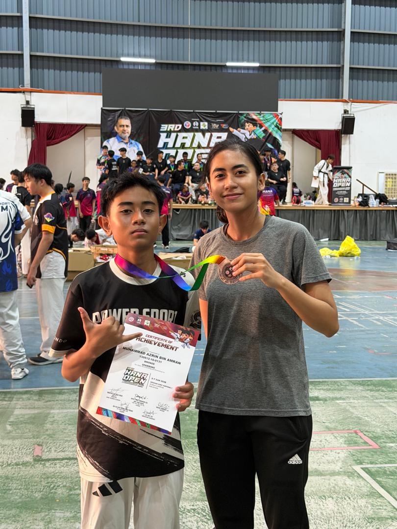 Power Sport student and coach with a medal